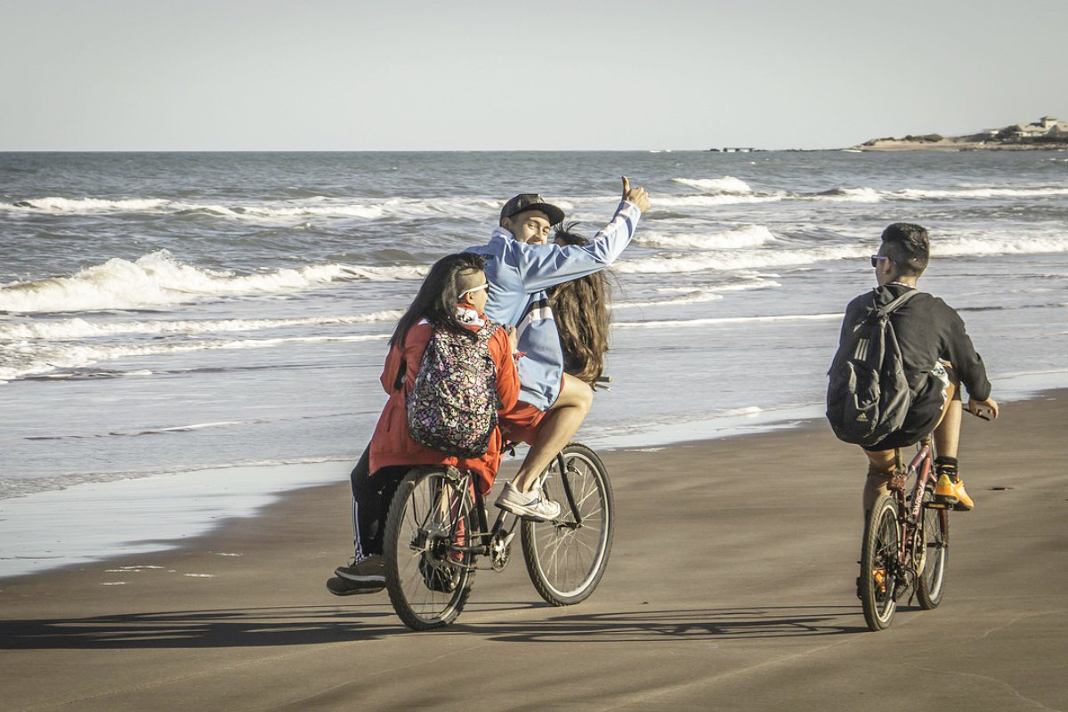 Jugendliche auf Fahrrädern am Meer entlangfahrend